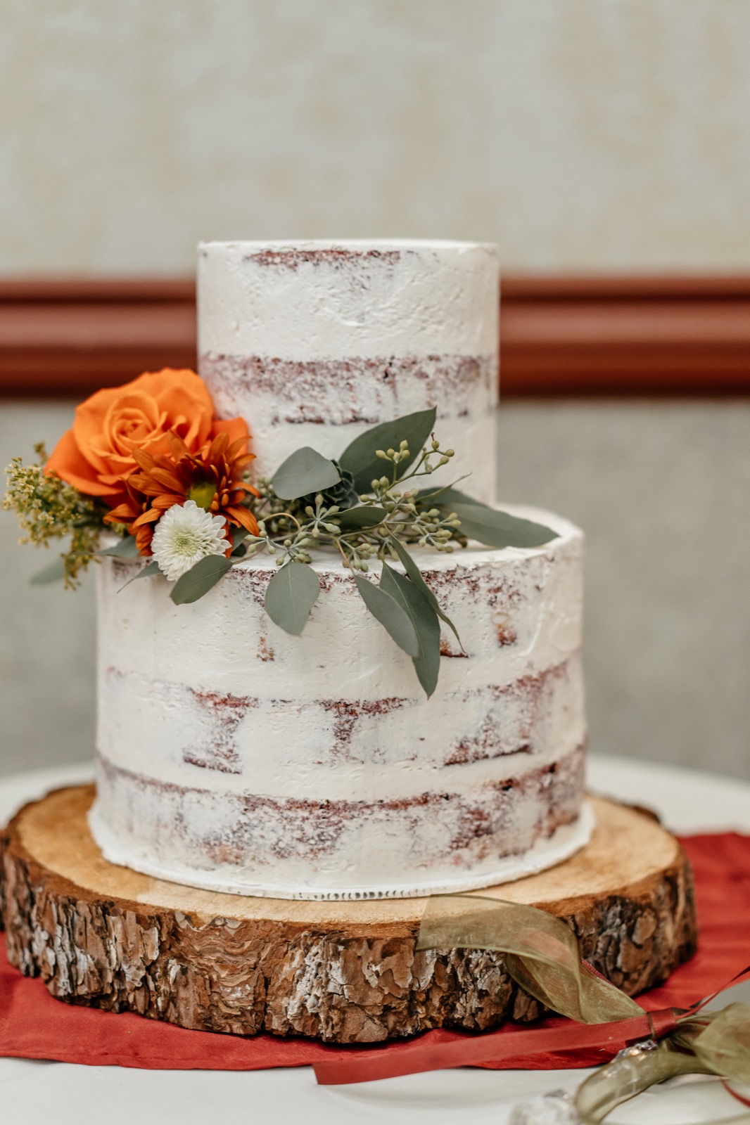 Rustic floral wedding cake on a wood slab stand